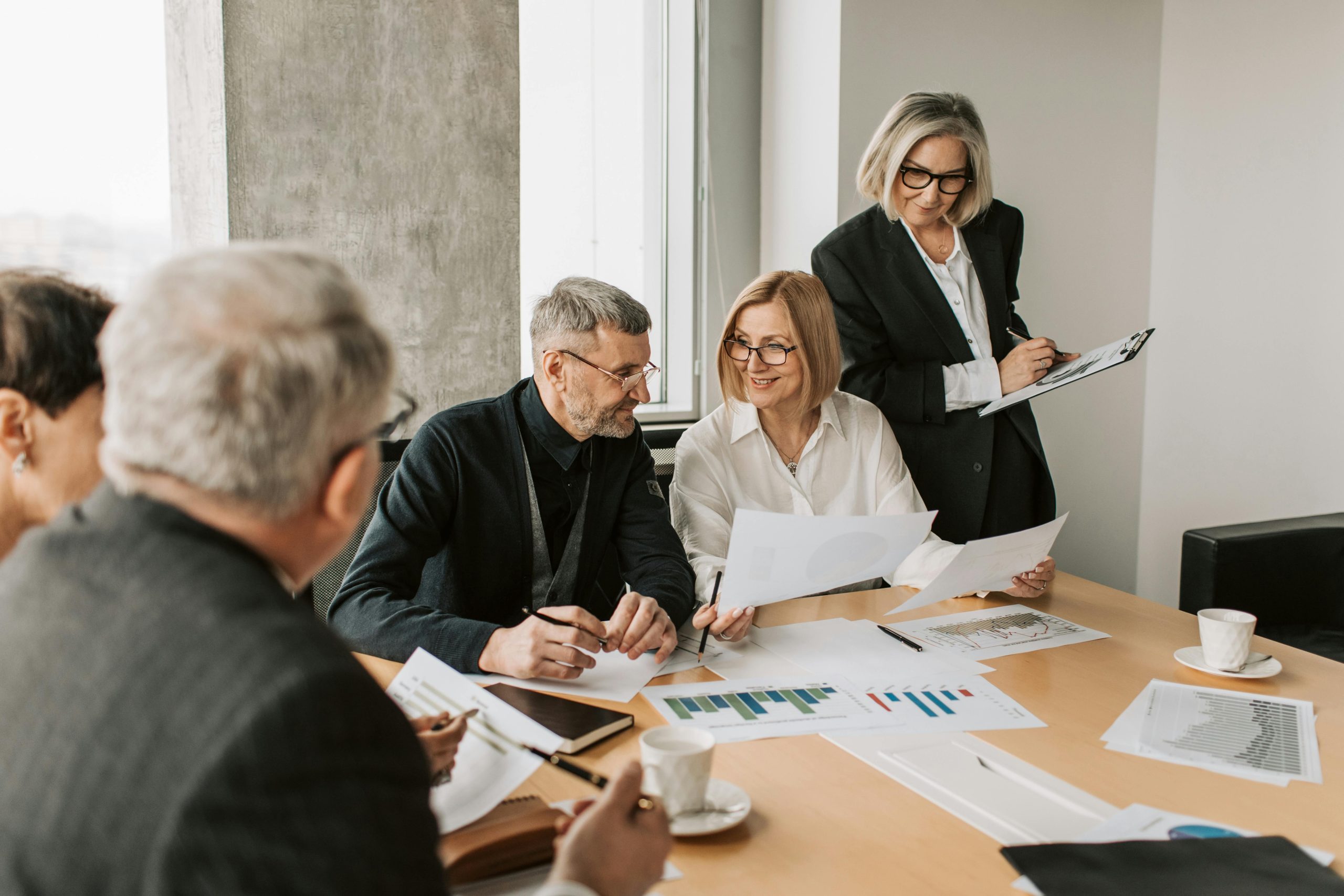 Five colleagues reviewing digital marketing strategy documents together